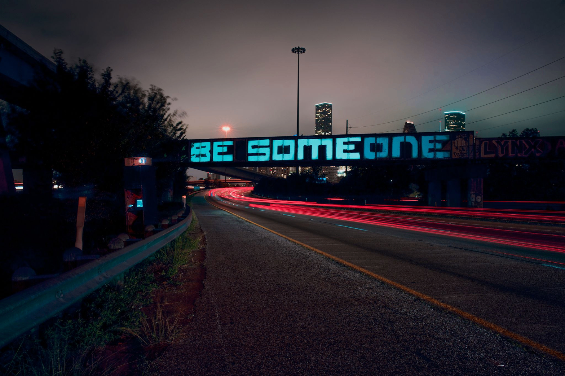 Houston's iconic BE SOMEONE graffiti bridge with downtown skyline at night